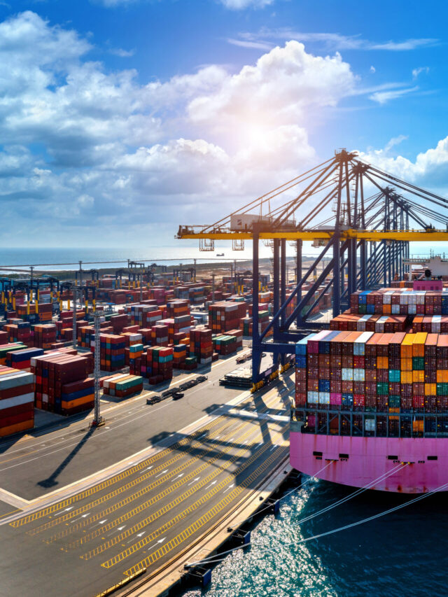 Aerial view of cargo ship and cargo container in harbor.